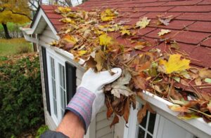 Cleaning gutters and downspouts as part of fall maintenance checklist