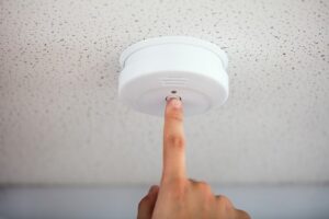 Replacing batteries and testing smoke and carbon monoxide detectors during fall home prep in West Michigan